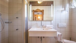 A bathroom with a shower, sink, and toilet. - traditionelles Ferienh. Soell (Söll)