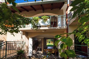 Un edificio de varios niveles con balcones, una escalera y plantas en macetas.