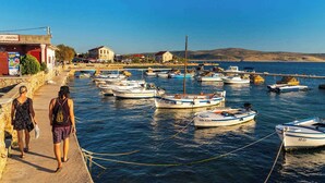 A harbor with boats docked, a building with a sign, and a clear blue sky.