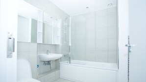 A modern bathroom with a toilet, sink, and glass-enclosed shower. - Highview 2-bed Apartment in London (London)