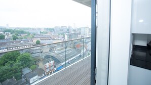 A high-rise building with a view of a cityscape, including buildings and a railway line. - Highview 2-bed Apartment in London (London)