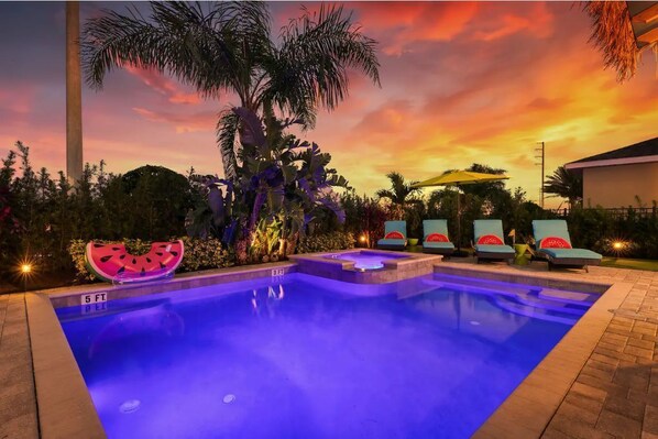 Relax by the pool surrounded by lush tropical vegetation and lounge chairs.