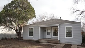 A single-story house with a front porch, a mailbox, and a large tree in the yard. - Cozy Cottage next to MSU Texas, centrally located!  (Wichita Falls)