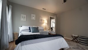 A bedroom with a bed, bedside tables, a lamp, a mirror, and a view of the hallway. - Cozy Cottage next to MSU Texas, centrally located!  (Wichita Falls)