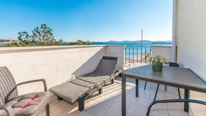 A balcony with a table and two lounge chairs, overlooking a coastal view. - Pet friendly apartment in Turanj with WiFi (Turanj)