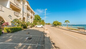 A coastal street with a row of multi-story buildings, a parked car, and a bench by the sea. - Pet friendly apartment in Turanj with WiFi (Turanj)