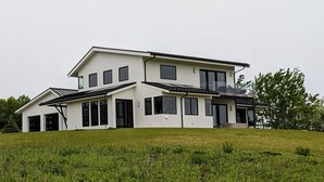 Ein modernes, zweistöckiges Haus mit großer Garage und überdachtem Außenbereich.