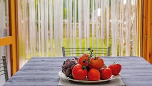 A table with a plate of tomatoes and artichokes. - Coraline Beach House (Mascali)