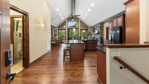 Une cuisine spacieuse dotée d’un îlot central, de meubles en bois et offrant une vue sur l’extérieur.