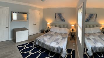 Une chambre avec deux lits, une commode, un miroir et des œuvres d’art accrochées aux murs.