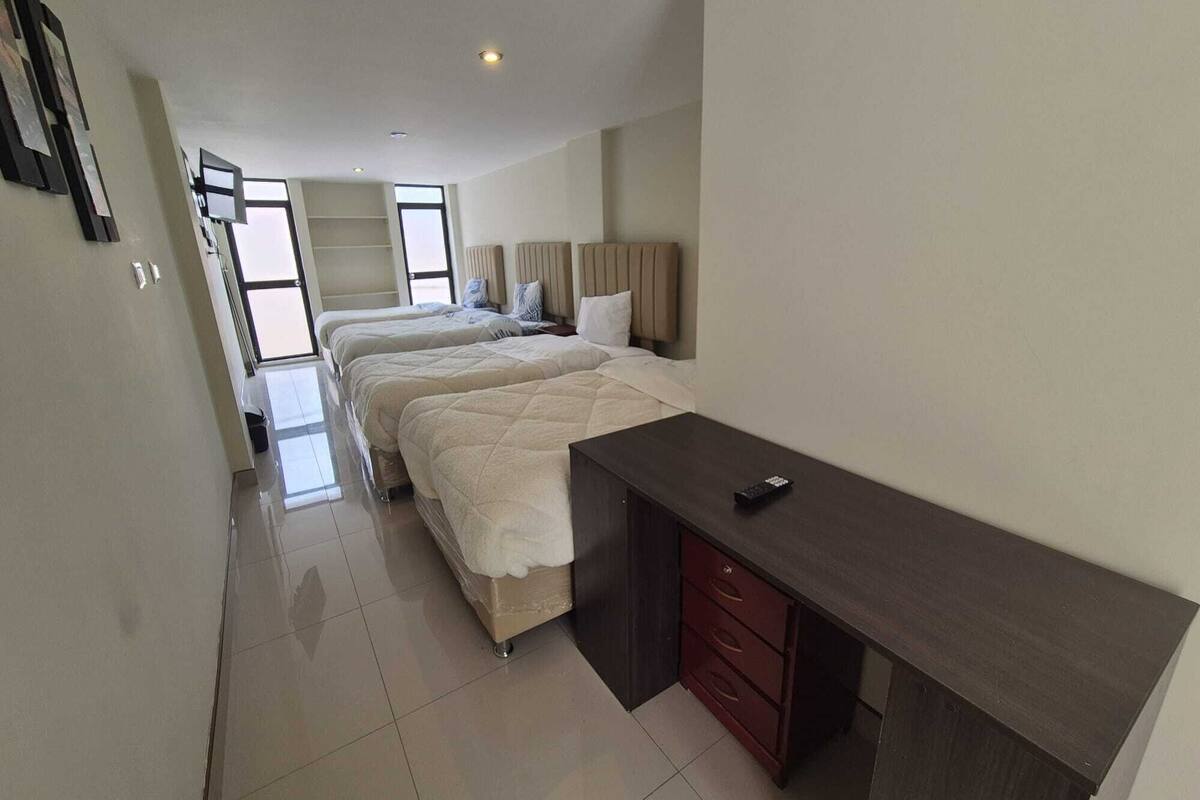 Een hotelkamer met twee bedden, een bureau en een kledingkast.