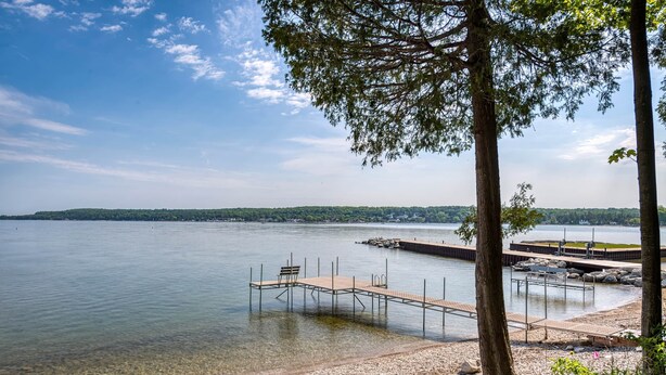 A lakeside dock with benches and a wooden walkway leading to the water. - Bayview Cottage Ephraim (Ephraim)