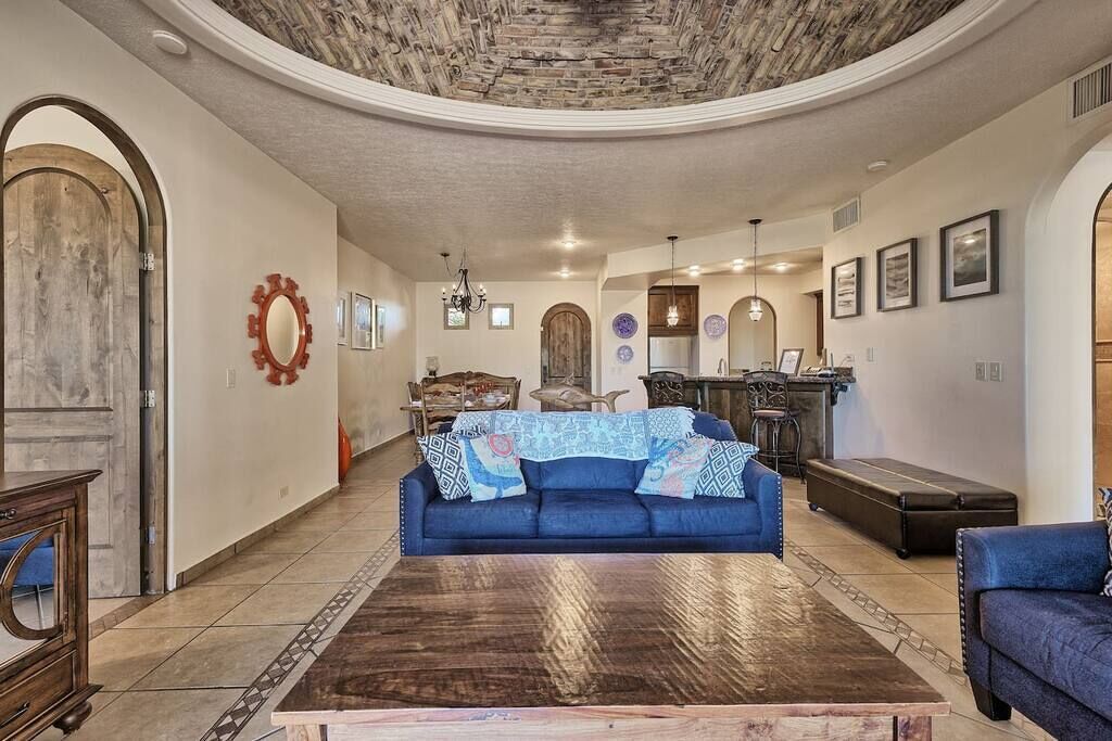 A spacious living room with a blue sofa, a wooden coffee table, and a stone ceiling.