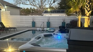 A hot tub with a control panel and a pool in a backyard. - Main Street Pool and Hot Tub Oasis BSL 039 (Bay St. Louis)