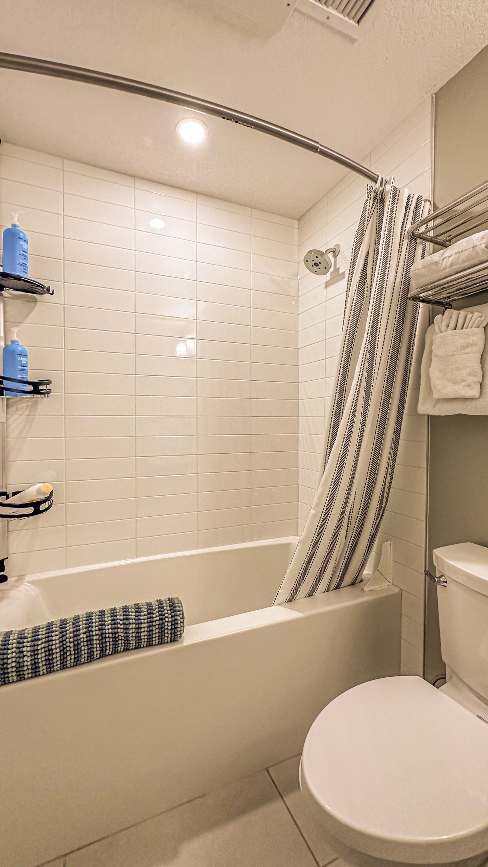 A bathroom with a bathtub, a toilet, and a shower area.