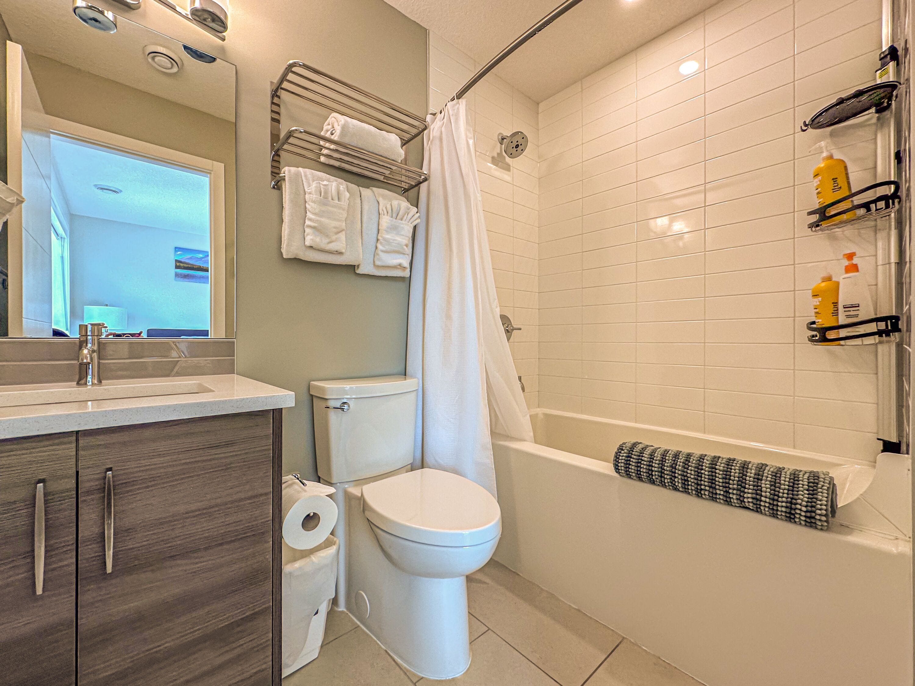 Une salle de bain moderne équipée de toilettes, d’un lavabo et d’un espace douche.