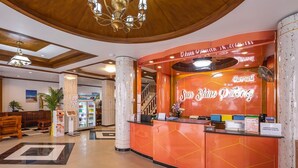 A hotel lobby with a reception desk, a staircase, and a seating area. - Sun Shine Patong (Patong)
