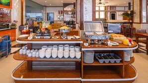A breakfast buffet setup with coffee, tea, and various food items. - Sun Shine Patong (Patong)