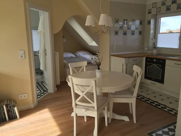 A compact kitchen with a dining area, a small oven, and a window with a view.