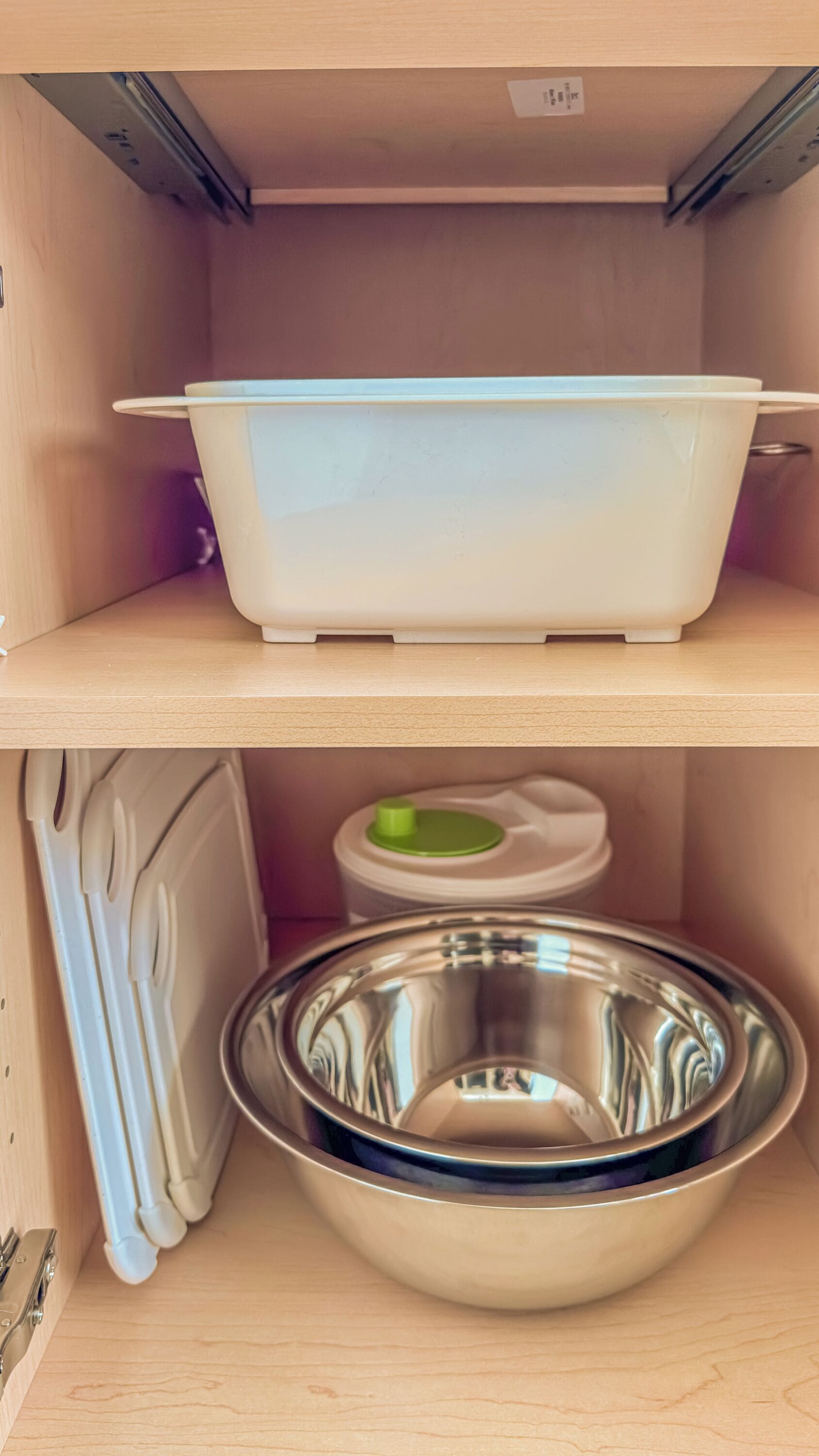 Une cuisine avec un plan de travail blanc, un saladier blanc et un saladier en acier inoxydable.