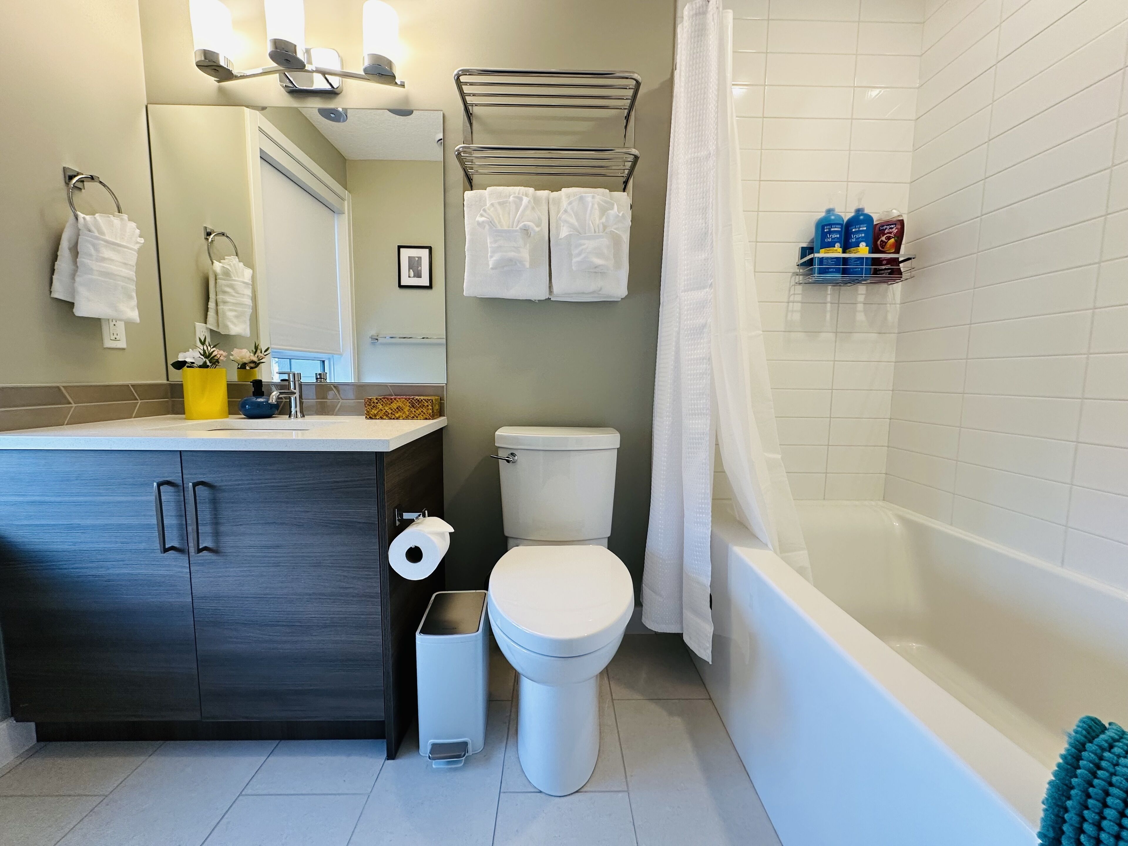 A modern bathroom with a toilet, sink, and bathtub.