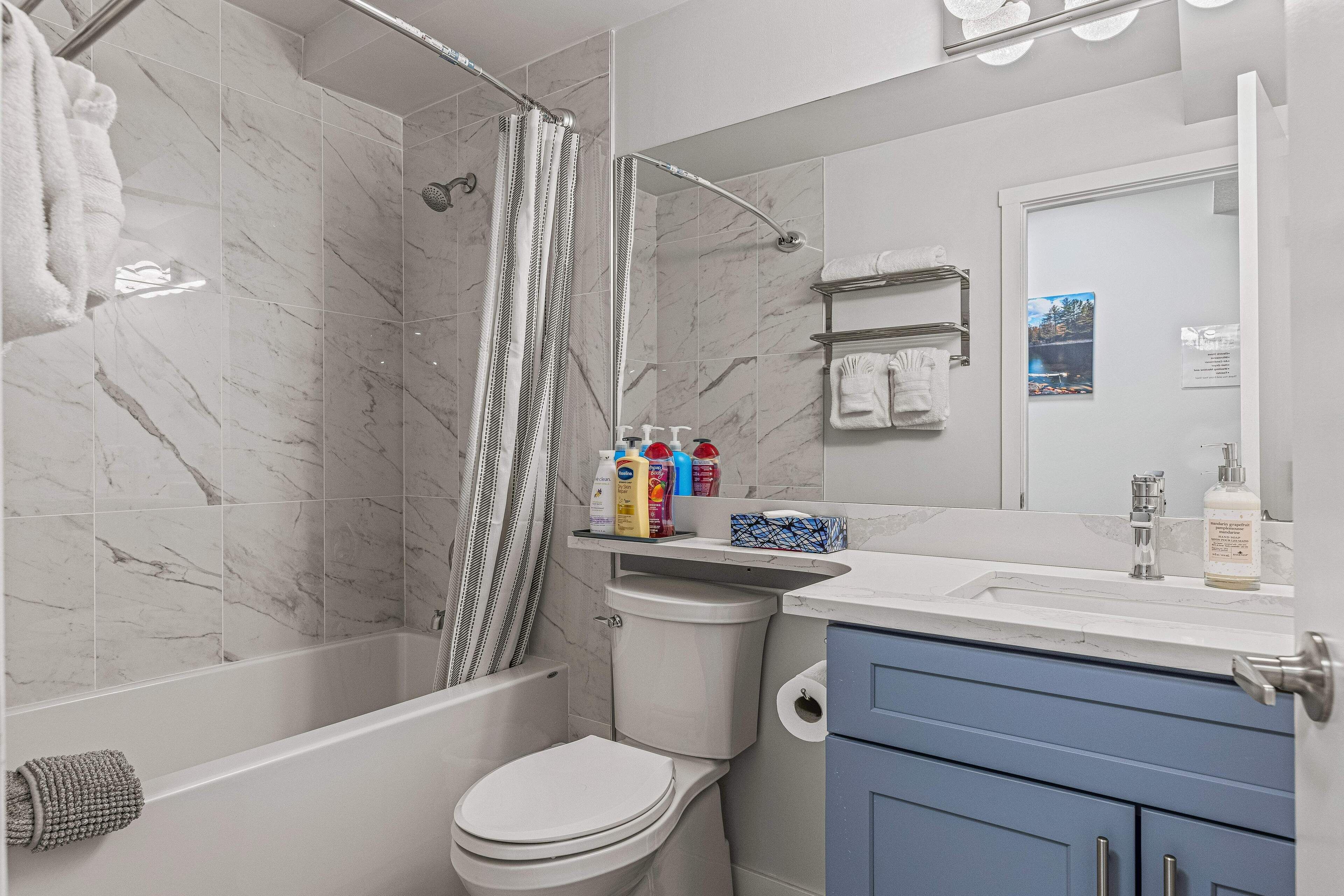 A bathroom with a shower, toilet, and sink.