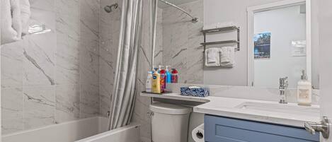 A bathroom with a shower, toilet, and sink.