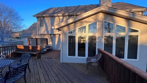 En uteplats med utemöbler, ett takförsett område och stora fönster.