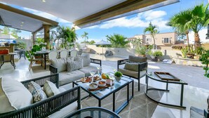 Un patio al aire libre con un sofá, sillas y una mesa de comedor.