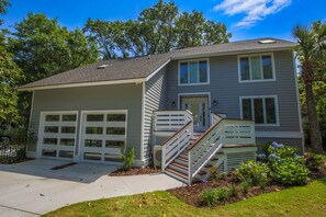 A two-story house with a garage, a covered porch, and a staircase leading to the second floor.