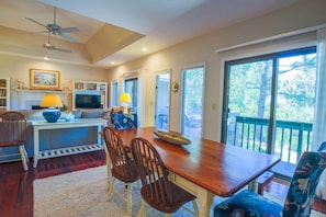 A spacious living room with a wooden dining table, comfortable seating, a fireplace, and a television.