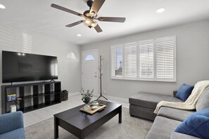 Relax in this stylish living room with a flat-screen TV, comfortable sofa, and armchair.