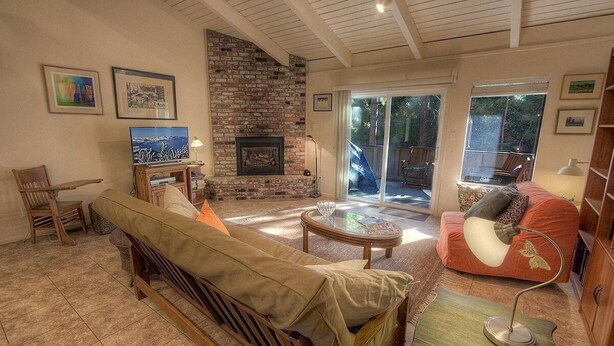 A cozy living room with a fireplace, a sofa, a coffee table, and a TV. - Sugar Pine 3 Bedroom Home by RedAwning (Incline Village)
