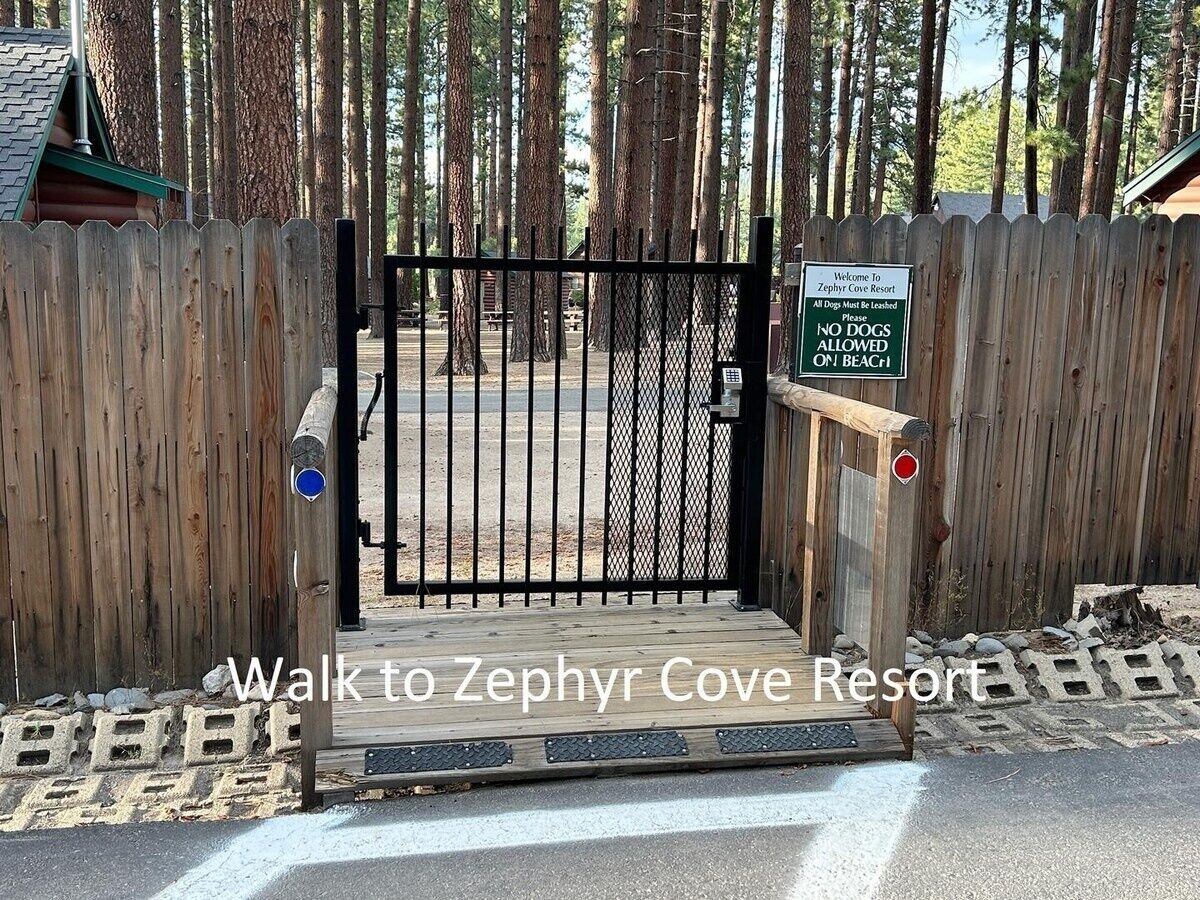 Ein hölzernes Tor mit einem Schild, das daraufhinweist, dass Hunde am Strand des Zephyr Cove Resort nicht erlaubt sind.