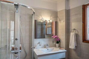 A bathroom with a glass-enclosed shower, a white sink, a mirror with lights, and a towel rack. - No 12 - Panoramic Terrace - Sustainable Home - Pure Nature (Rethymno)
