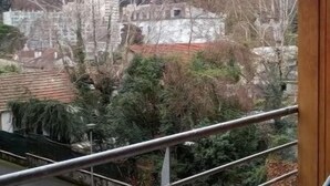 A balcony with a view of a snow-covered mountain, a parked car, and buildings in the background. - nice apartment very well located, covered parking (Lourdes)