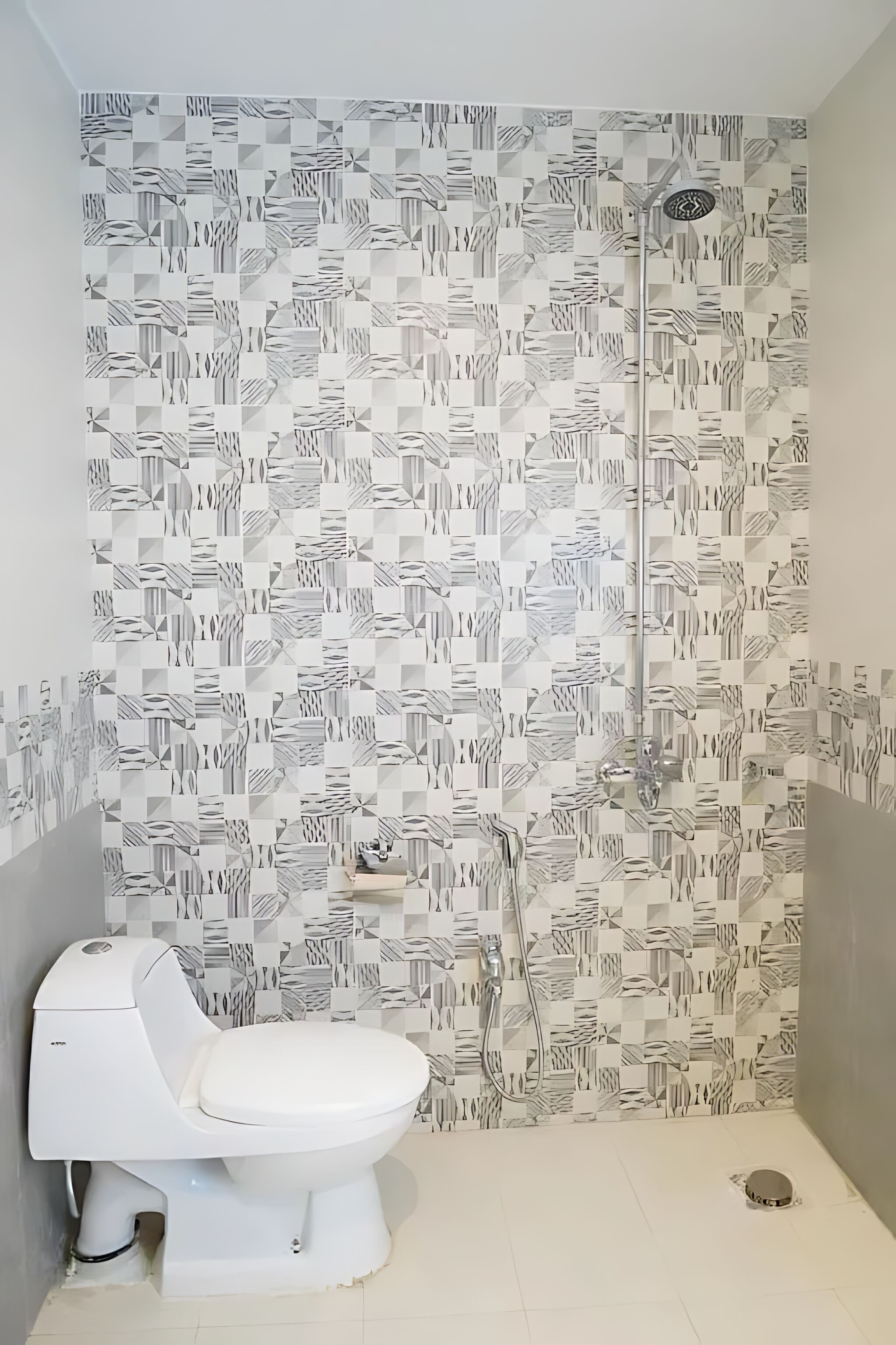 Une salle de bain avec un mur à motifs, des toilettes et une douche.