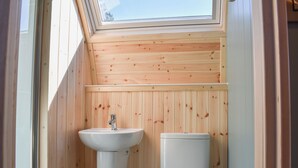A small, wooden-paneled bathroom with a skylight, a sink, and a toilet. - 1 bedroom accommodation in Wangford, near Southwold (Wangford, near Southwold)