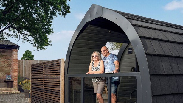 A modern, curved-roofed structure with a glass door, a brick wall, and a wooden fence in the background. - 1 bedroom accommodation in Wangford, near Southwold (Wangford, near Southwold)