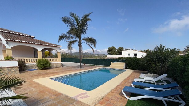 A swimming pool with tiled flooring, palm trees, and lounge chairs. - Quiet private pool villa (Xàbia)