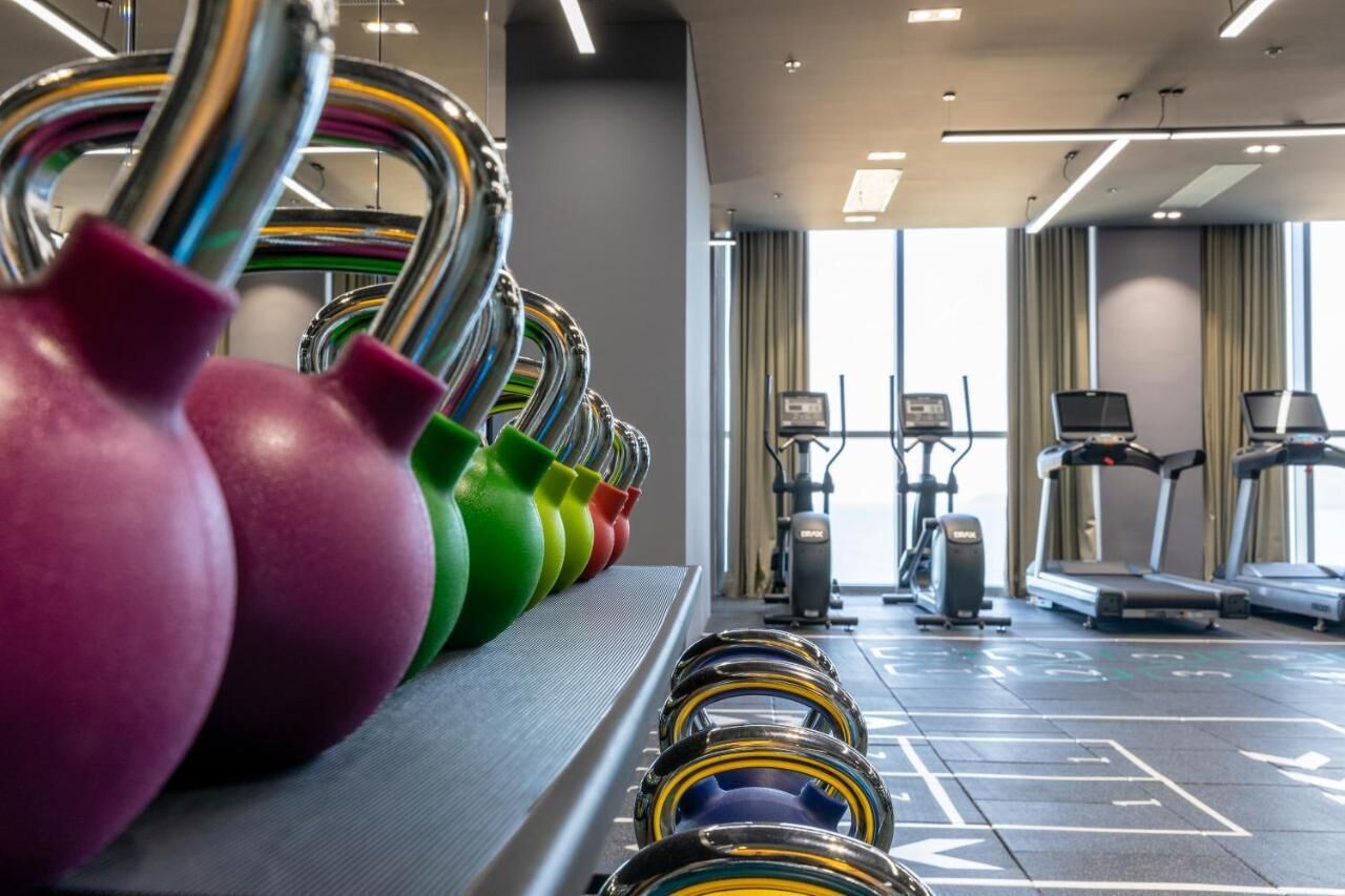 A gym with exercise equipment, treadmills, and a weightlifting area.