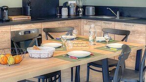 A modern kitchen with a dining area, equipped with a stove, sink, and various appliances. - Charming Gîte with Private Pool near Amboise, Sleeps 5, Fully Equipped (Saint-Règle)