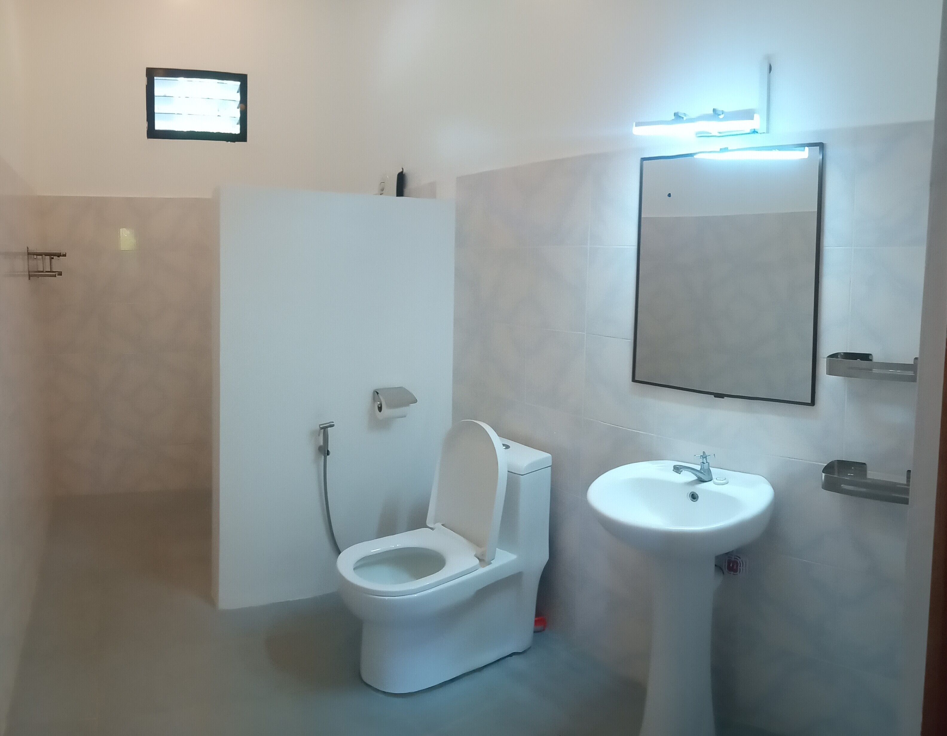 A modern bathroom with a toilet, sink, and mirror.