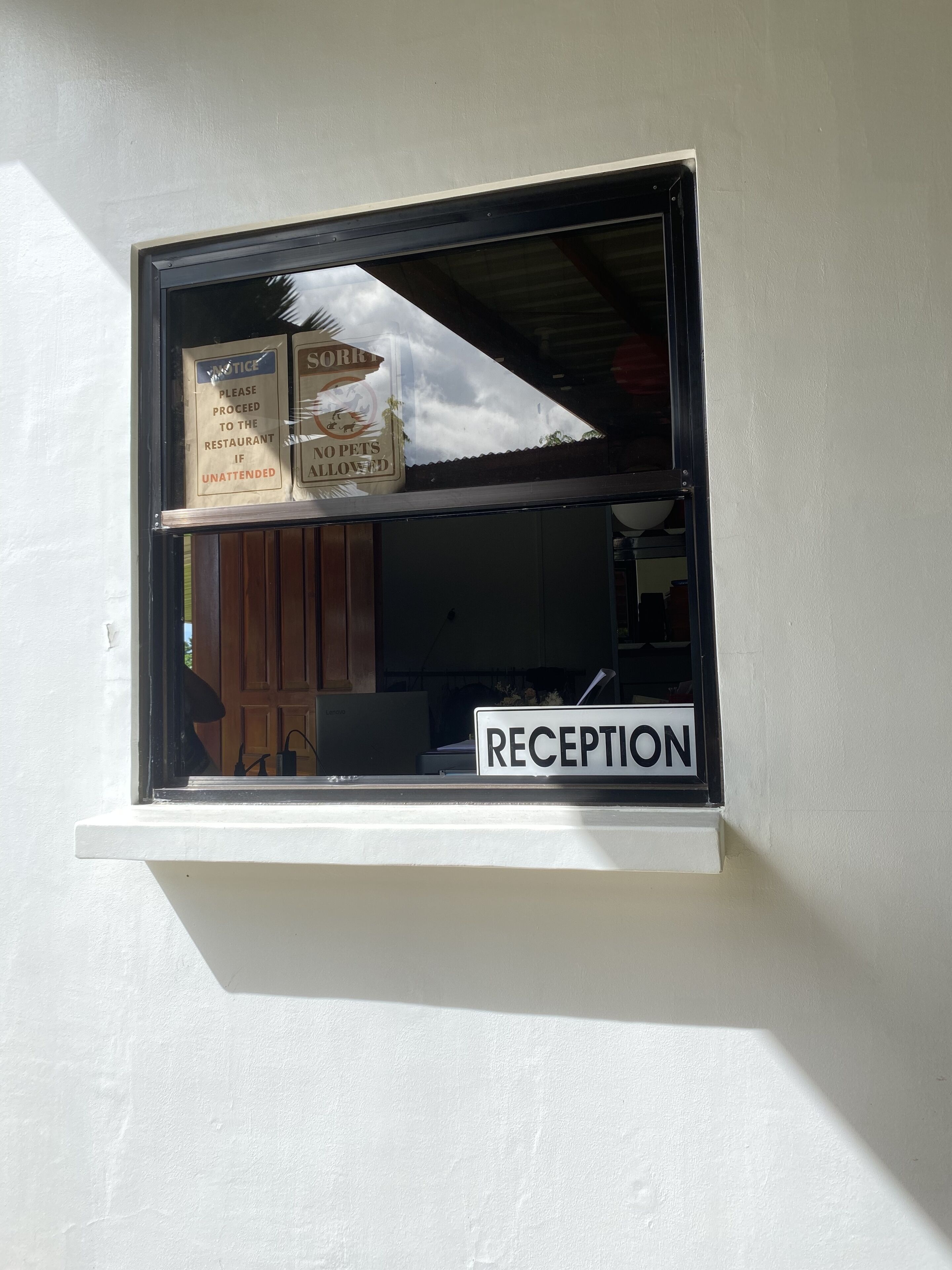 A window with a 'RECEPTION' sign and a 'NOTICE' sign indicating no pets allowed.