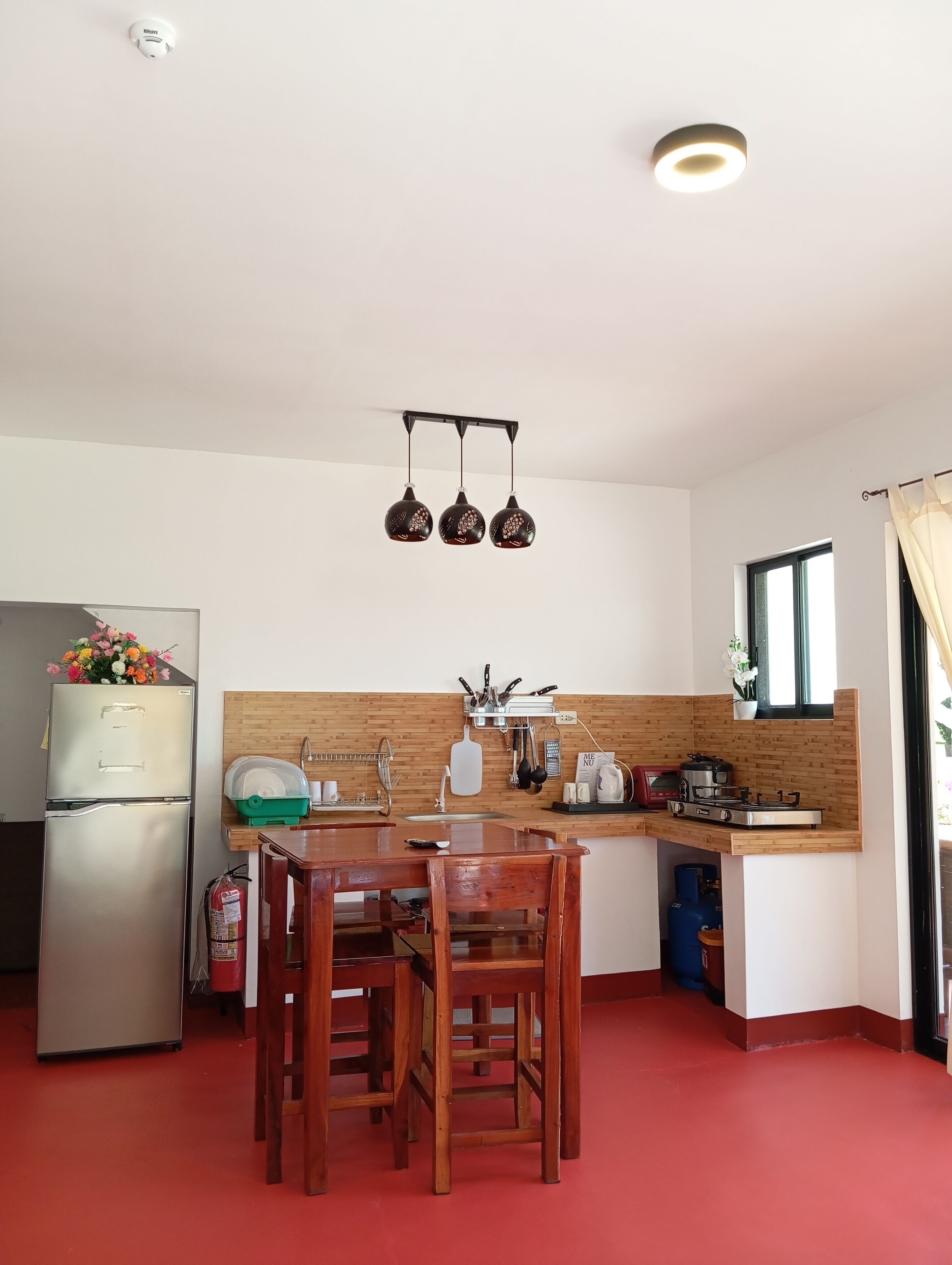 Una cocina compacta con refrigerador, estufa y encimera de madera.