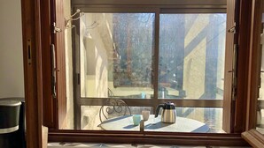 A kitchen with a window overlooking a balcony. - LA PETITE MAISON à TARNAC en CORRÈZE (Tarnac)