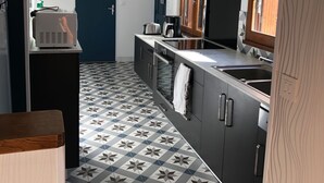 A compact kitchen with a tiled floor, a built-in oven, a sink, and a window with a view. - LA PETITE MAISON à TARNAC en CORRÈZE (Tarnac)