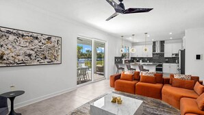 A modern living room with a sofa, coffee table, and artwork. - Hi340sd: 5 Bed, Storybook Village, Karaoke (Melbourne Beach)
