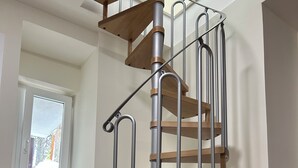 A spiral staircase with metal railings and wooden steps, leading to an upper floor. - Vacation home located in the heart of Cilento a few steps from the sea (Centola)