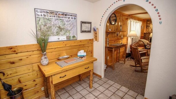 Un bureau en bois avec une carte, un vase et une boîte de mouchoirs.